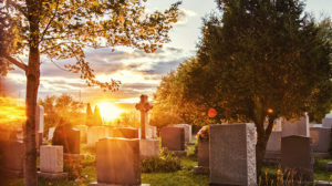 A sunset behind headstones